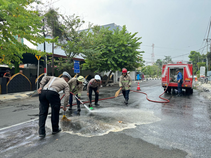 Sigap, Polisi bersama Damkar Bersihkan Tumpahan Solar di Jalan Raya Lamongan Antisipasi Kecelakaan